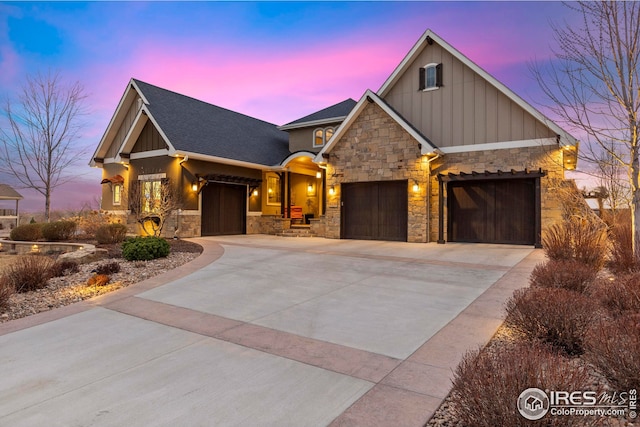 craftsman-style house featuring stone siding, roof with shingles, concrete driveway, board and batten siding, and a garage