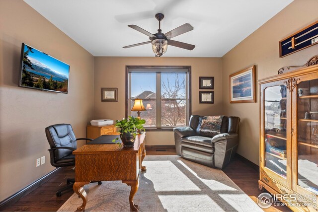 office space featuring baseboards, ceiling fan, and wood finished floors
