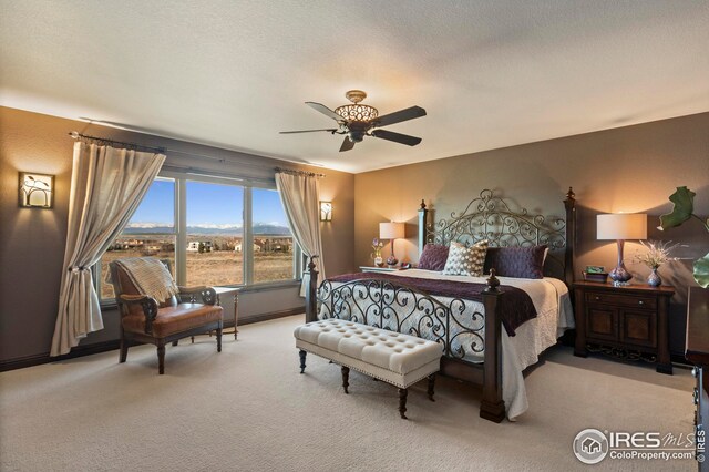 carpeted bedroom with a ceiling fan and a textured ceiling