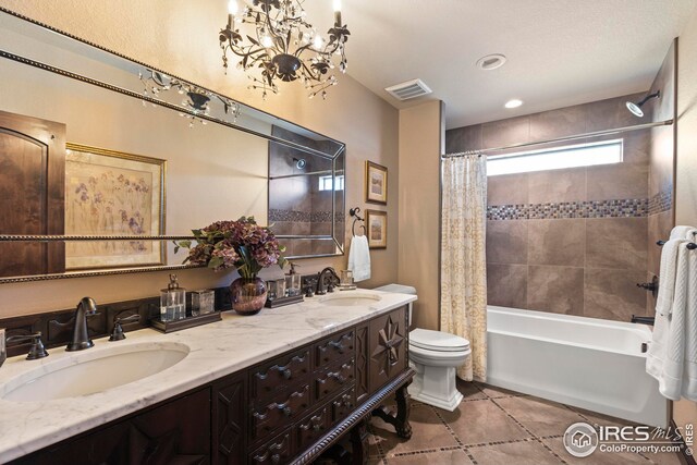 bathroom featuring visible vents, toilet, a sink, and an inviting chandelier