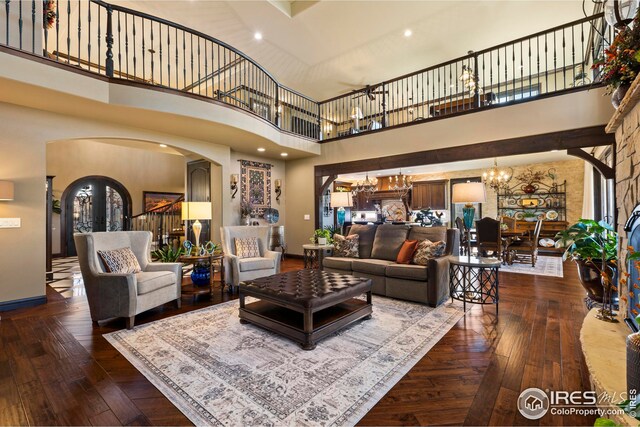 living room with an inviting chandelier, arched walkways, hardwood / wood-style flooring, and baseboards