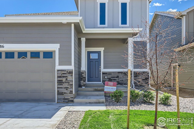 786 Griffith St, Lochbuie, CO 80603 - view of exterior entry featuring board and batten siding, a garage, stone siding, and concrete driveway