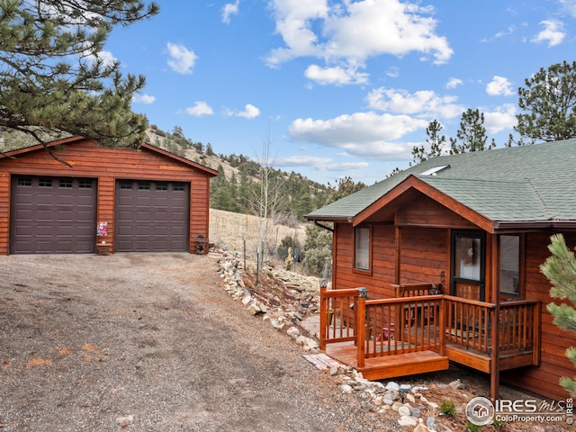 view of home's exterior with an outbuilding, roof with shingles, and a garage
