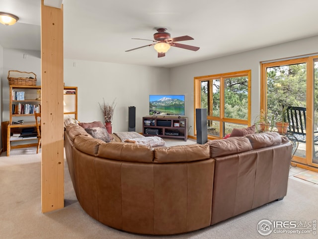 living area featuring light colored carpet and a ceiling fan
