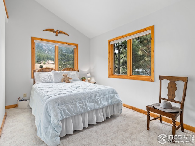 carpeted bedroom featuring baseboards and vaulted ceiling
