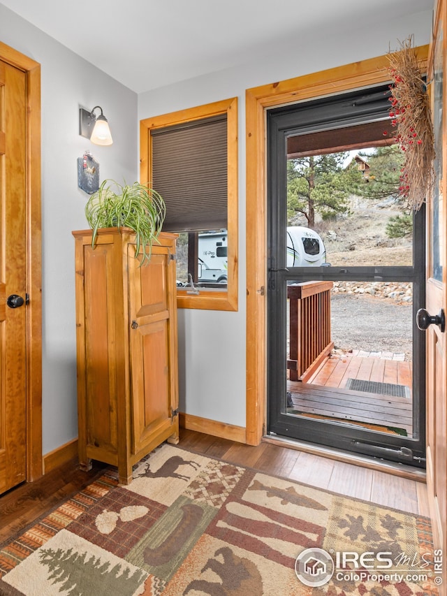doorway to outside featuring wood-type flooring and baseboards