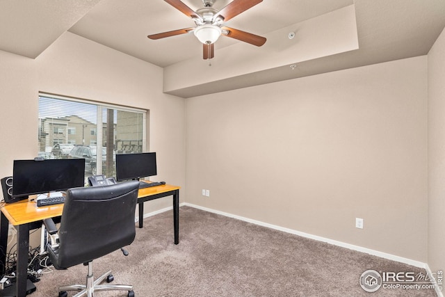 carpeted office space with baseboards and a ceiling fan