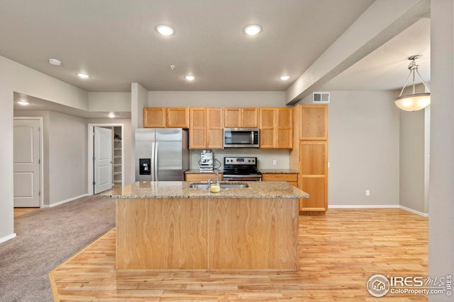 kitchen featuring light stone counters, a sink, appliances with stainless steel finishes, visible vents, and recessed lighting