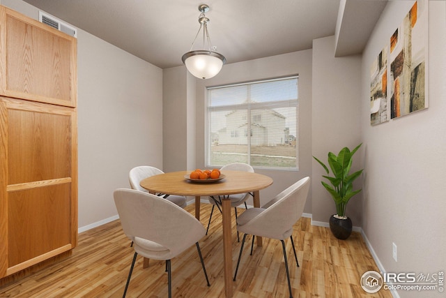 dining area with baseboards, visible vents, and light wood-style floors