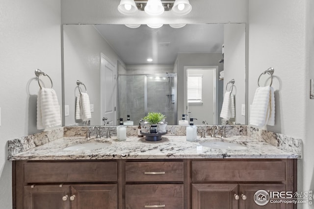 full bathroom with a shower stall and double vanity