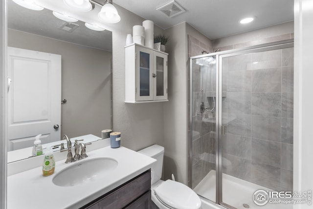 full bathroom with a shower stall, toilet, and vanity