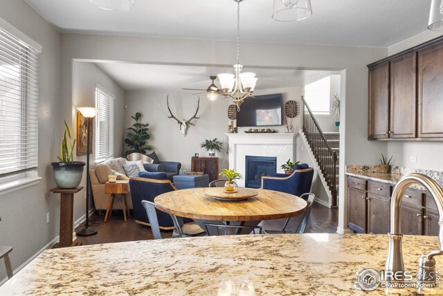 dining room featuring baseboards, a glass covered fireplace, and dark wood-style flooring