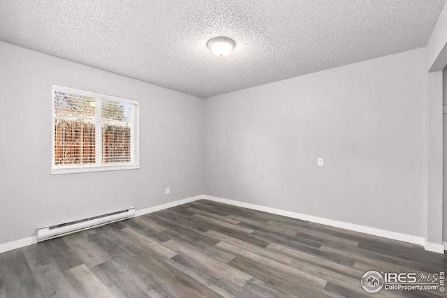 spare room featuring dark wood finished floors, baseboards, and baseboard heating