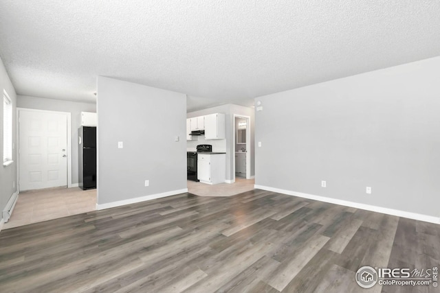 unfurnished living room featuring a textured ceiling, baseboards, and dark wood-style flooring