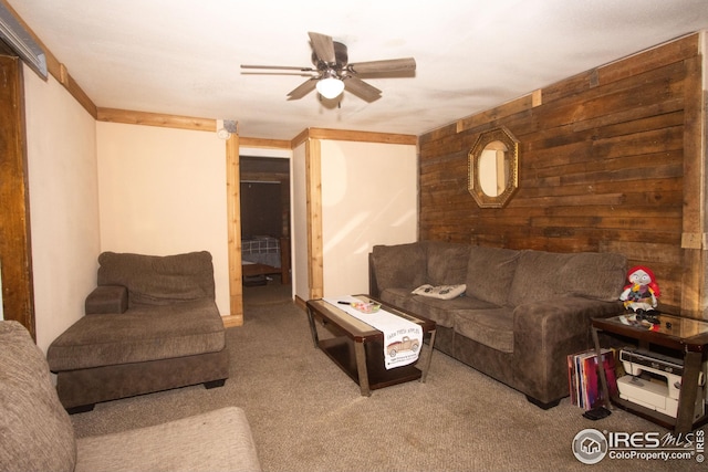 carpeted living room featuring wood walls and ceiling fan