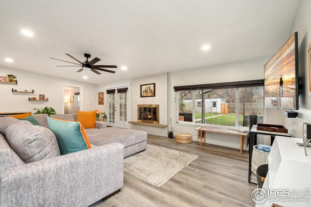 living area featuring recessed lighting, light wood-style flooring, a ceiling fan, and french doors