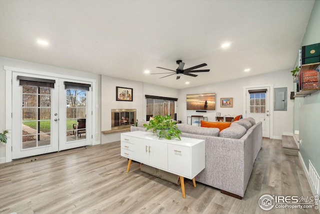 living area with light wood finished floors, a glass covered fireplace, baseboards, recessed lighting, and a ceiling fan