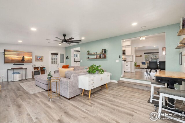 living area featuring light wood-type flooring, baseboards, recessed lighting, and ceiling fan