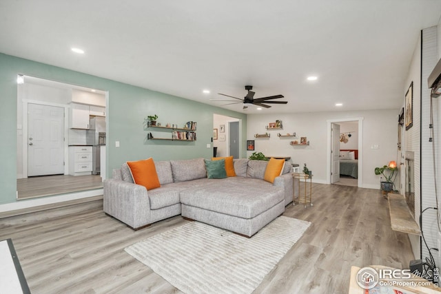 living area featuring light wood finished floors, baseboards, recessed lighting, and ceiling fan