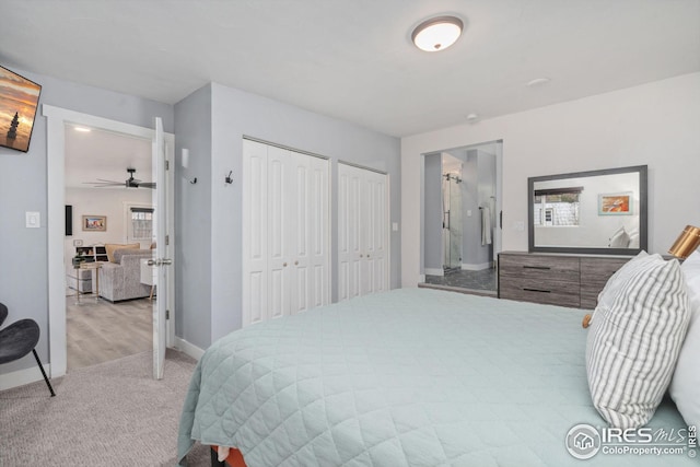 carpeted bedroom with multiple closets and baseboards