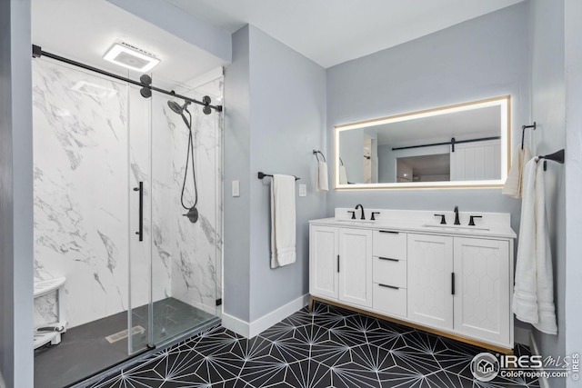 full bath with baseboards, a marble finish shower, a sink, and double vanity