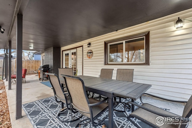 view of patio / terrace featuring grilling area, fence, outdoor dining space, and french doors