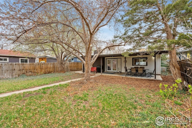 view of front of house featuring fence, a patio area, french doors, and a front yard