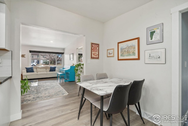dining area featuring light wood-type flooring and baseboards