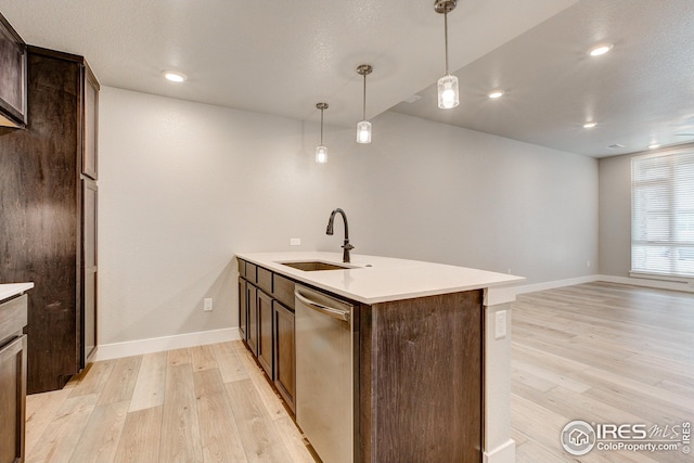kitchen featuring light wood-style floors, stainless steel dishwasher, a sink, and dark brown cabinetry