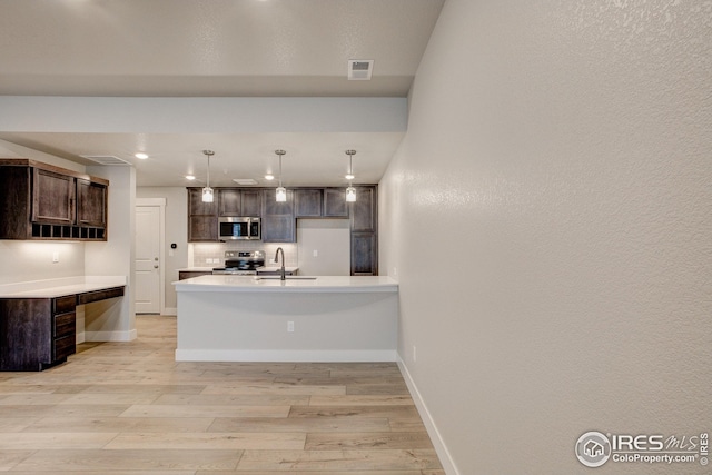 kitchen featuring dark brown cabinetry, light wood-style flooring, light countertops, visible vents, and appliances with stainless steel finishes