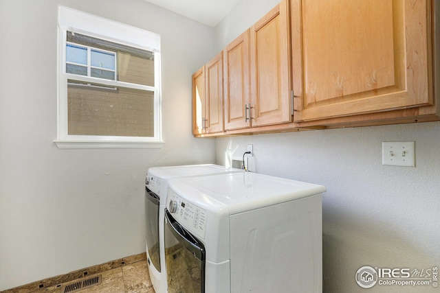 laundry room with separate washer and dryer, cabinet space, baseboards, and visible vents