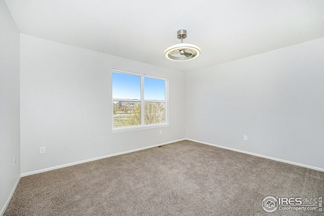 carpeted spare room featuring baseboards