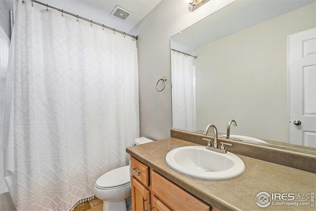 bathroom with toilet, visible vents, curtained shower, and vanity