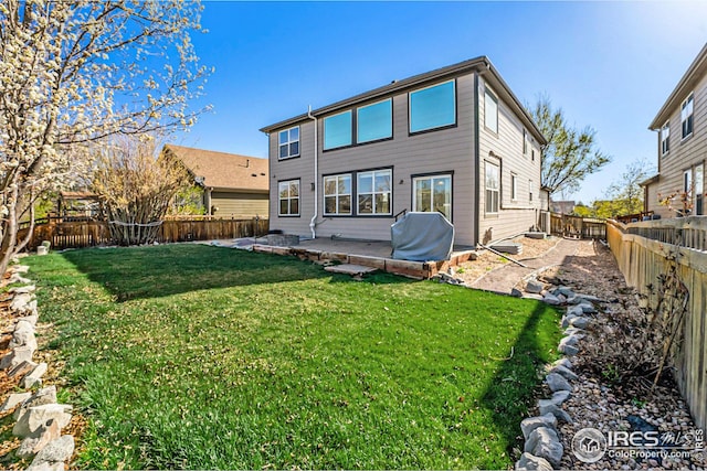 rear view of property with a yard and a fenced backyard