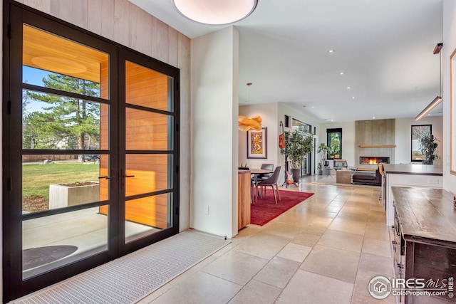 entrance foyer featuring light tile patterned floors, a fireplace, and a wealth of natural light