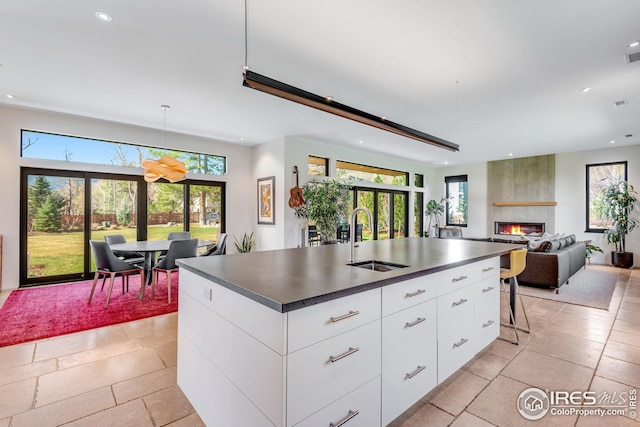 kitchen featuring recessed lighting, a sink, modern cabinets, and dark countertops