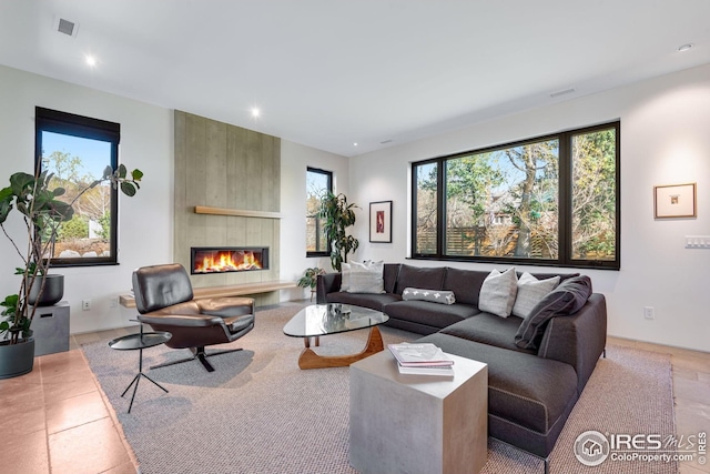 living room with a large fireplace, visible vents, and recessed lighting