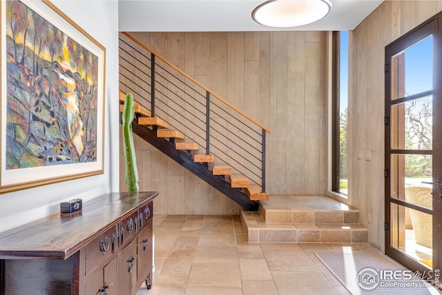 entrance foyer featuring wooden walls and stairway