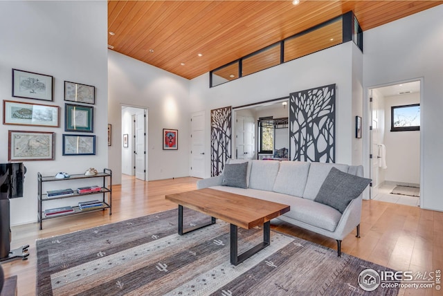 living area with recessed lighting, a high ceiling, wood finished floors, and wood ceiling