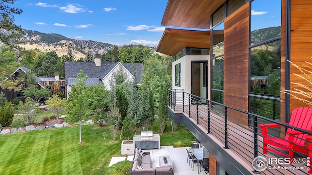 view of property exterior with a patio area, a mountain view, and a lawn