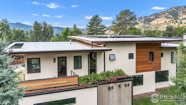 back of property featuring a mountain view and stucco siding