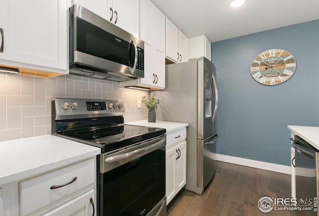 kitchen featuring white cabinets, appliances with stainless steel finishes, dark wood-style flooring, decorative backsplash, and baseboards