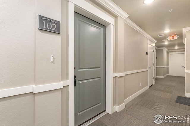corridor featuring baseboards, ornamental molding, recessed lighting, carpet floors, and visible vents