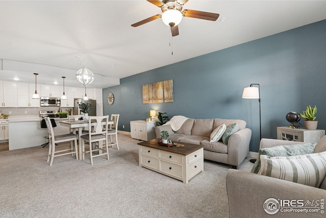 living area with light colored carpet and a ceiling fan