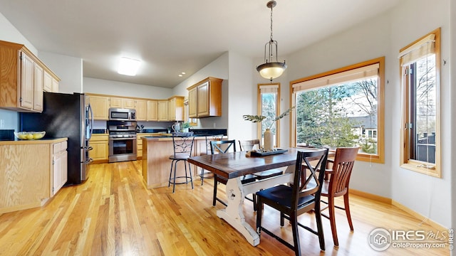 dining room with light wood finished floors and baseboards