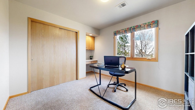 home office featuring visible vents, baseboards, and light carpet