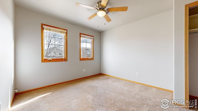 carpeted spare room with baseboards and ceiling fan