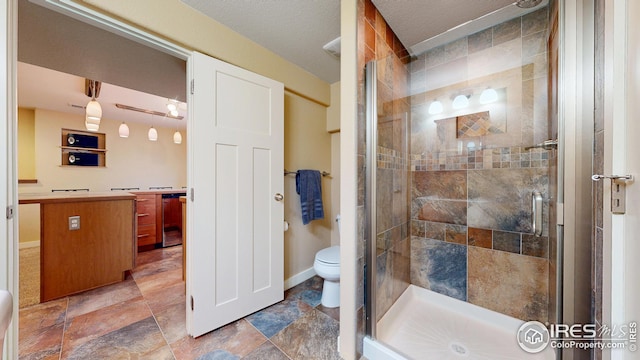 bathroom with toilet, a stall shower, vanity, and baseboards