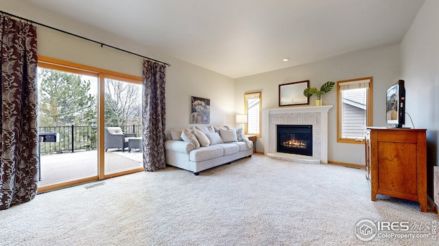 living area featuring visible vents, baseboards, carpet floors, and a fireplace