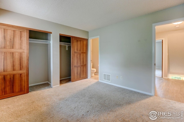 2924 Ross Dr Unit H20, Fort Collins, CO 80526 - unfurnished bedroom featuring baseboards, visible vents, a textured ceiling, and multiple closets
